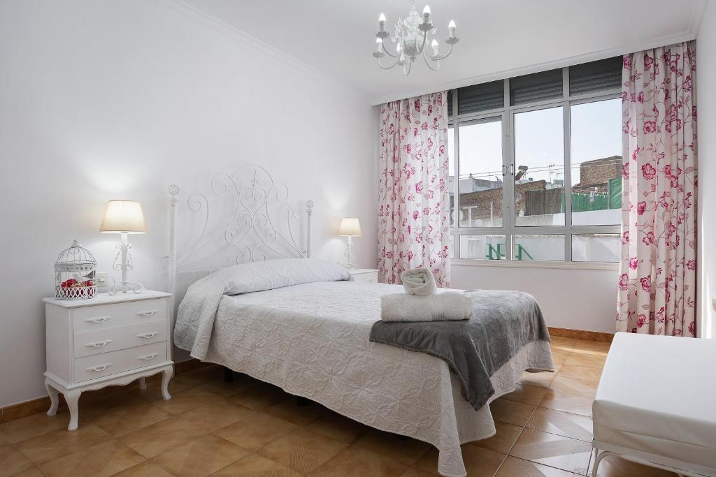 ein weißes Schlafzimmer mit einem Bett und einem Fenster in der Unterkunft Casa Pedro in Conil de la Frontera