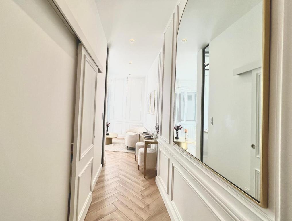 um corredor com um espelho e uma sala de estar em L incomparable - International Palace em Vichy