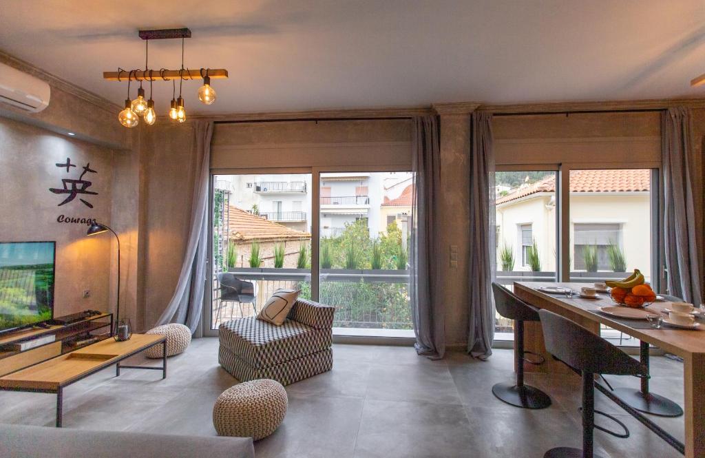 a living room with a table and a large window at Lepanto Luxury Apartments FF in Nafpaktos
