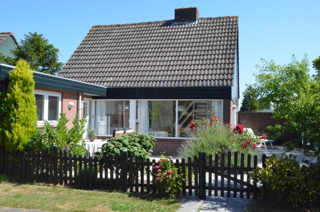una casa con una valla delante de ella en Zeelicht, en Noordwijkerhout