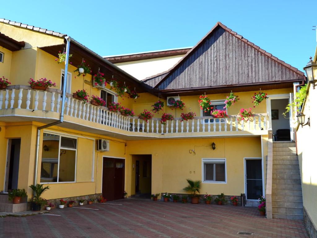una casa amarilla con flores en los balcones en Pensiunea Alexander, en Arad