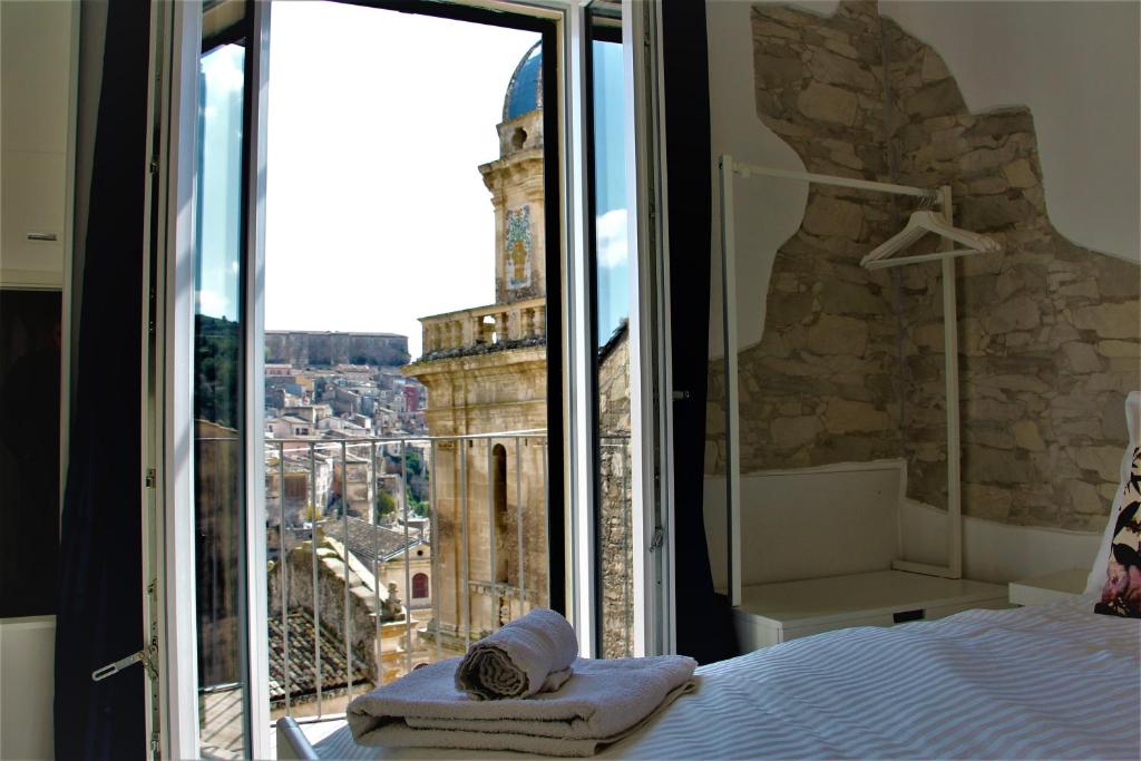 1 dormitorio con cama y vistas a la torre en B&B Belvedere All'Idria, en Ragusa