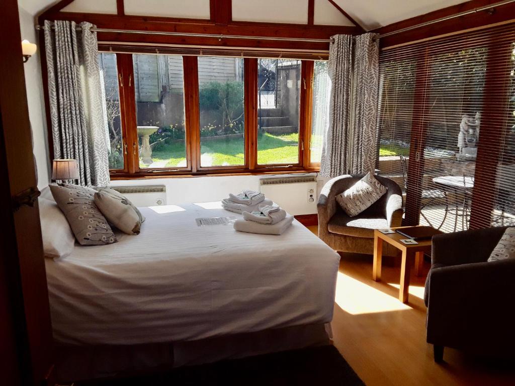 a bedroom with a bed in a room with windows at Whortleberry Studio B & B in Porlock