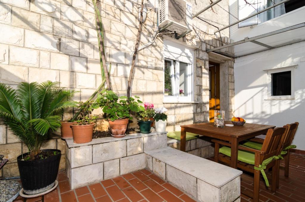 a patio with a table and potted plants at White Wave Guest House in Dubrovnik
