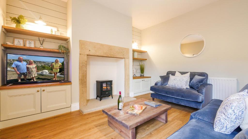 a living room with a couch and a tv at The Roman Apartment in Hexham