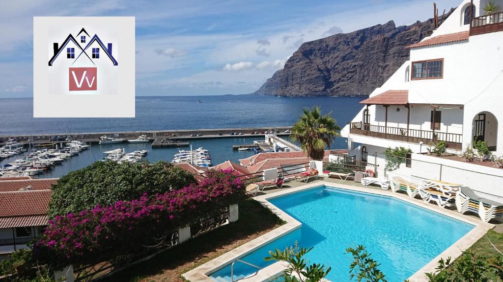 a view of a hotel with a pool and the ocean at Apartment mit Sonnenterrasse und Panorama - Meerblick, 5 Min. von Hafen + Strand in Acantilado de los Gigantes