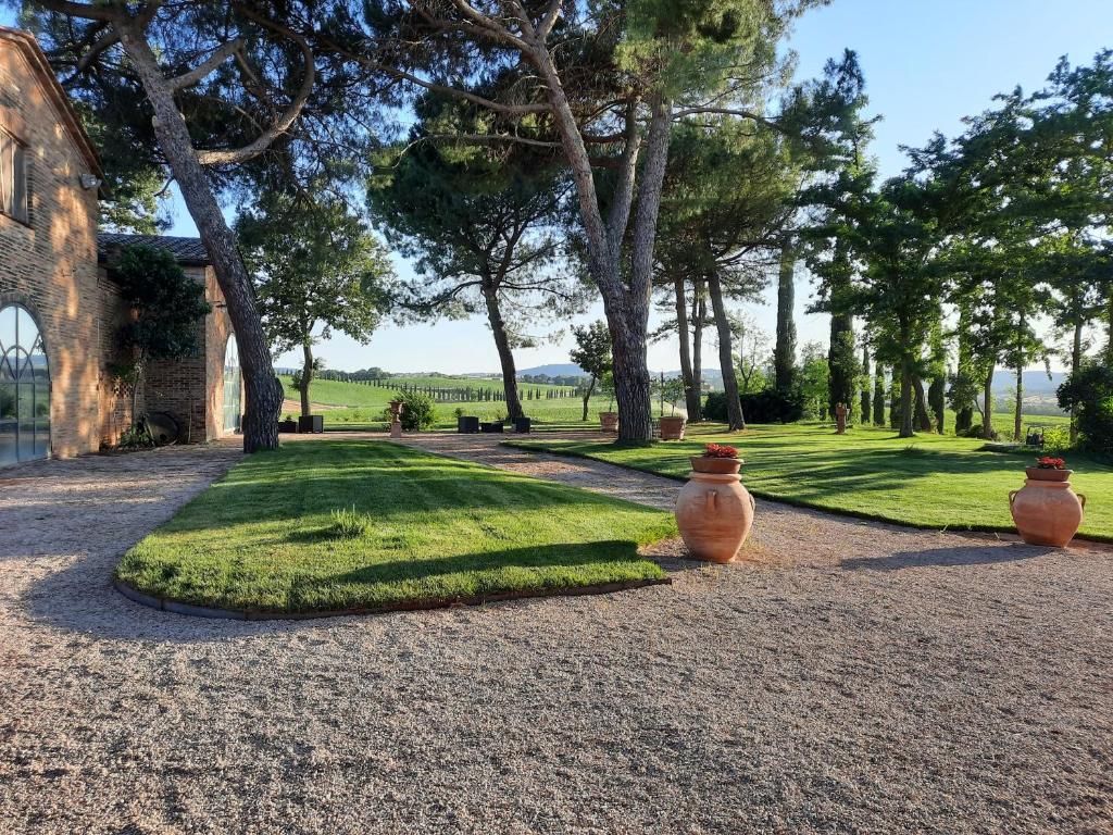 dos jarrones sentados en el suelo en un parque en Agriturismo IL GREPPO, en Abbadia di Montepulciano