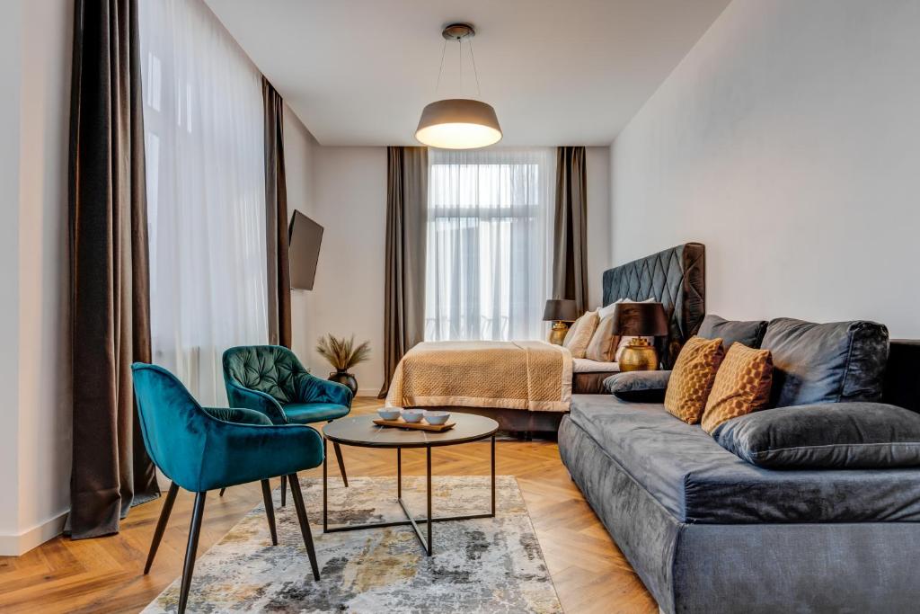 uma sala de estar com um sofá, uma mesa e cadeiras em Hotel Central Park em Poděbrady