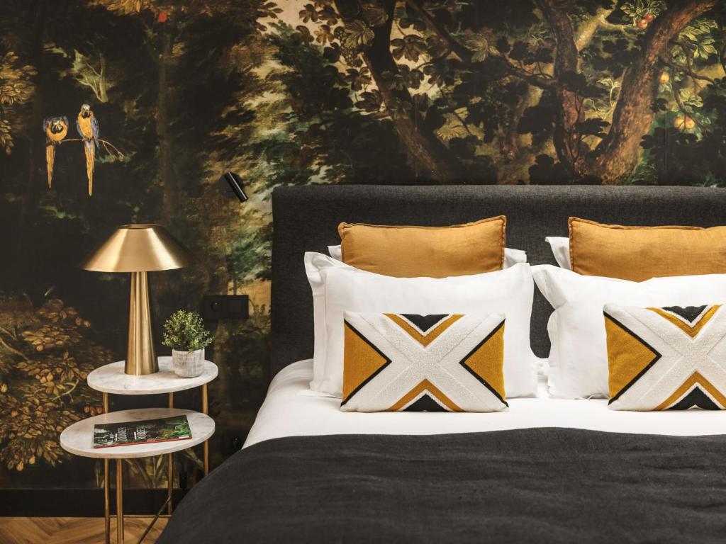 a bedroom with a bed with pillows and a painting at Maisons du Monde Hôtel & Suites - Marseille Vieux Port in Marseille