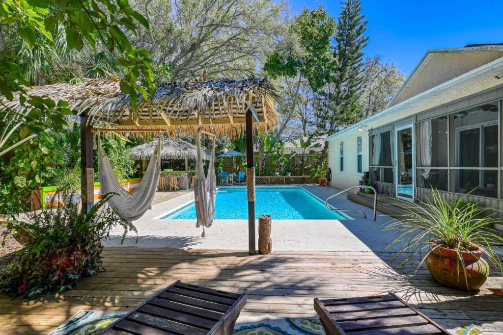 a backyard with a hammock and a swimming pool at Tiki Nest in Saint Augustine