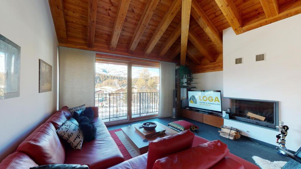 a living room with a red couch and a tv at Abitaziun Gioviel - Silvaplana Surlej in Surlej