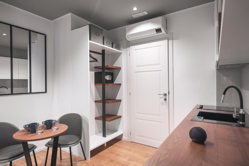 a kitchen with a table and chairs and a shelf at Residenze Chamur- Grattacielo in Palermo