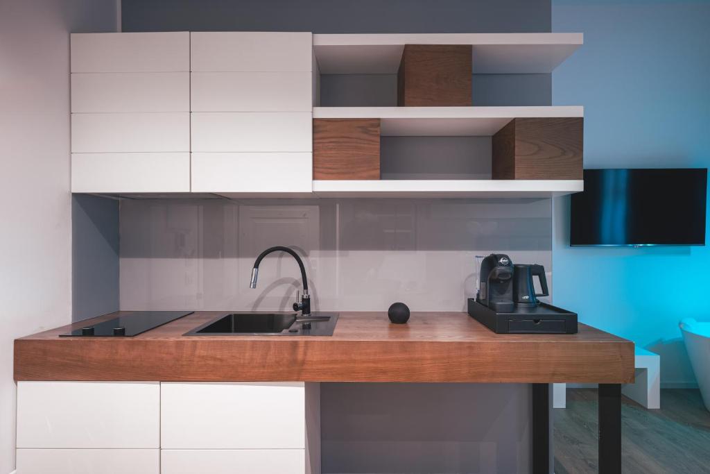 a kitchen with white cabinets and a sink at Residenze Chamur- Grattacielo in Palermo