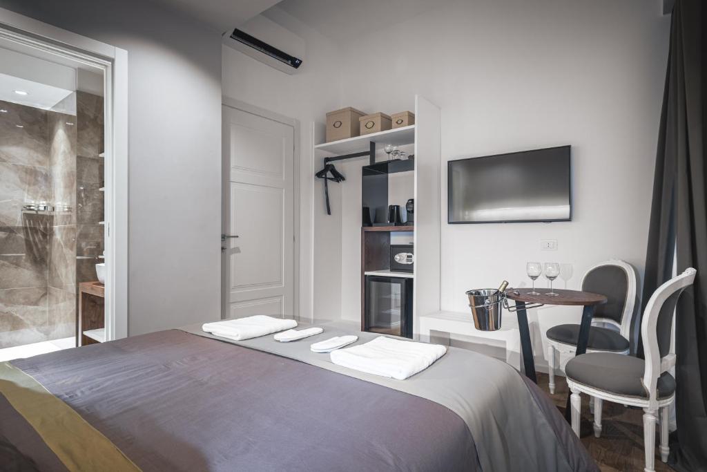 a bedroom with a bed and a table with a chair at Residenze Chamur- Grattacielo in Palermo