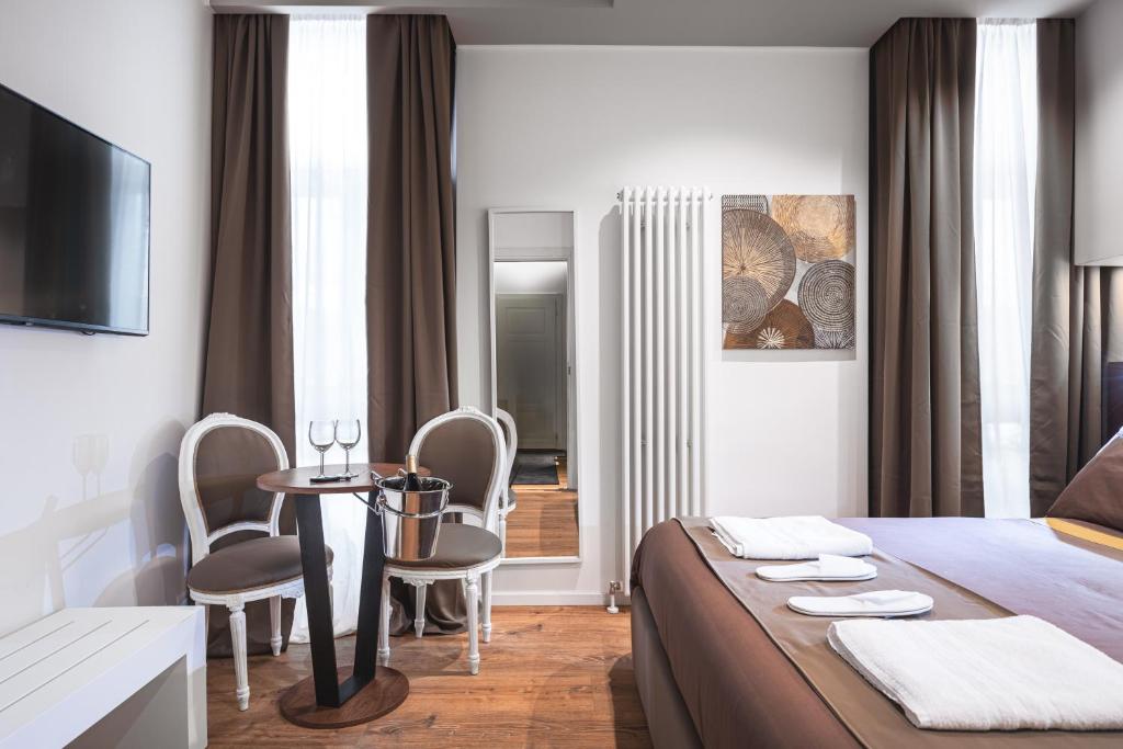 a hotel room with a bed and a table and chairs at Residenze Chamur- Grattacielo in Palermo