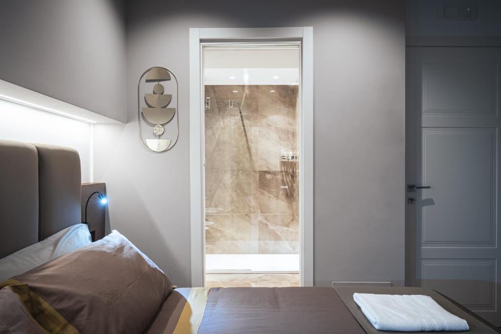 a bedroom with a bed and a glass door at Residenze Chamur- Grattacielo in Palermo