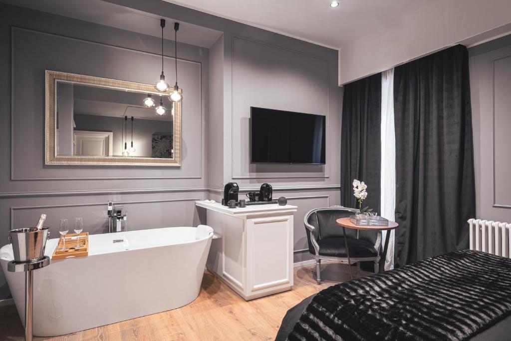 a bathroom with a tub and a bed and a television at Residenze Chamur- Grattacielo in Palermo