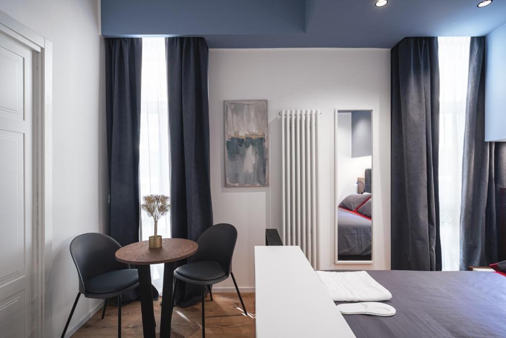 a living room with a table and chairs and a bedroom at Residenze Chamur- Grattacielo in Palermo
