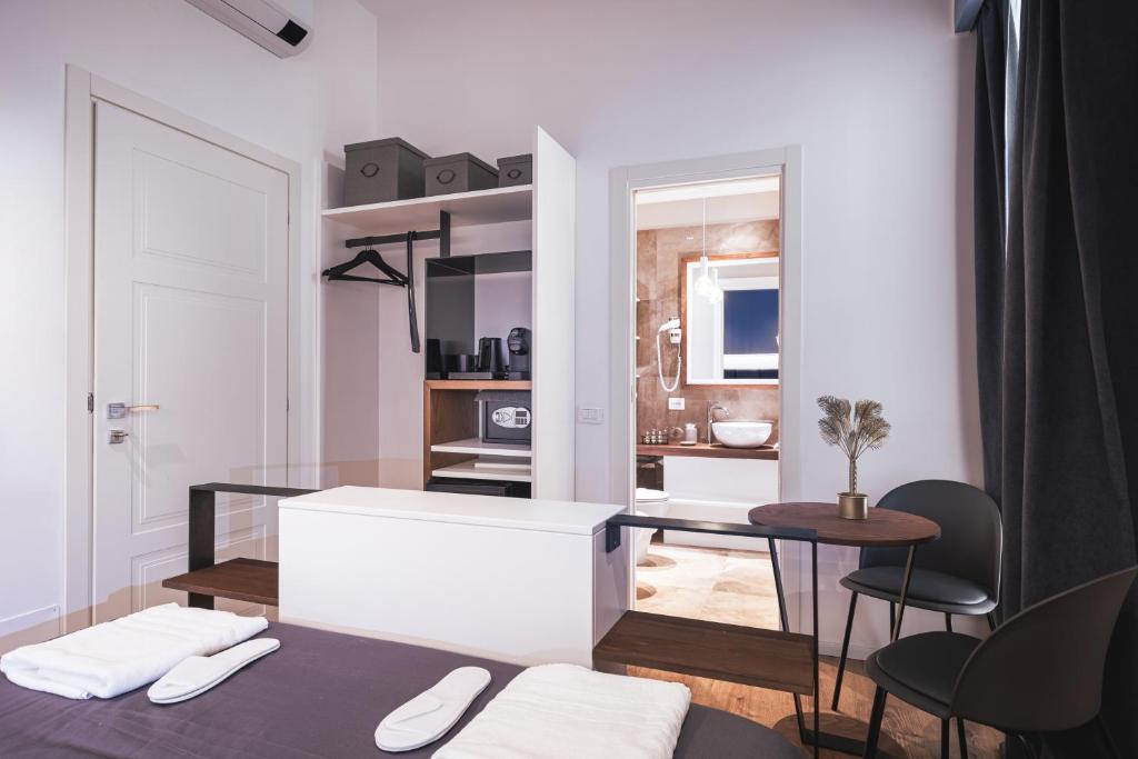 a living room with a table and a kitchen at Residenze Chamur- Grattacielo in Palermo
