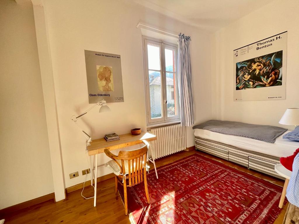 a bedroom with a desk and a bed and a window at Casa Tranquilla in Cannobio
