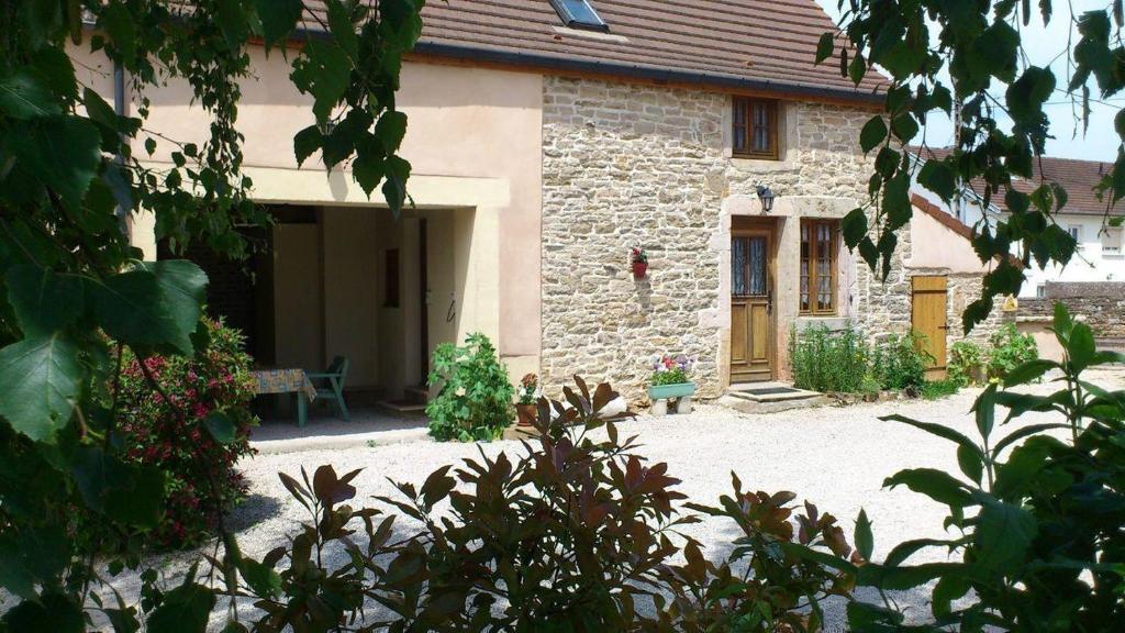 a stone house with a bench in front of it at L'Escargot in Corgoloin