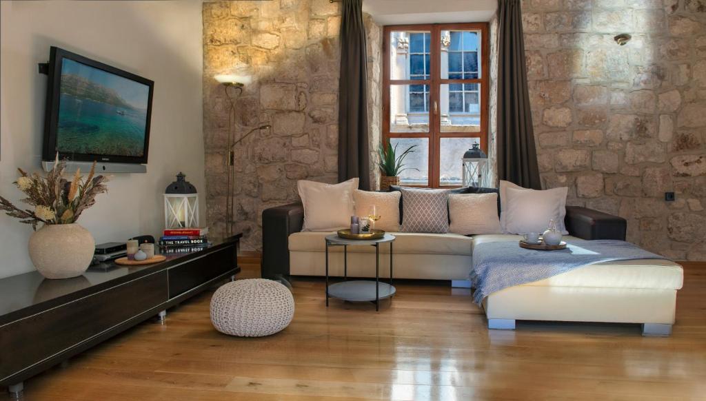 ein Wohnzimmer mit einem Sofa und einem Tisch in der Unterkunft Loft in Ismaelli Palace Korcula in Korčula