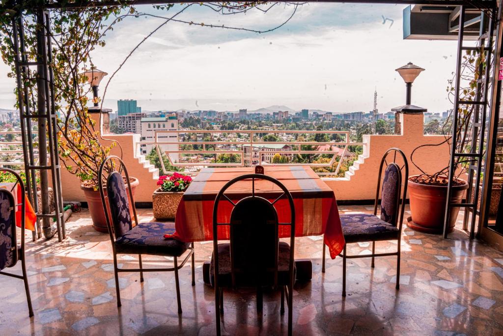 un tavolo e sedie su un balcone con vista di Ras Amba Hotel ad Addis Abeba