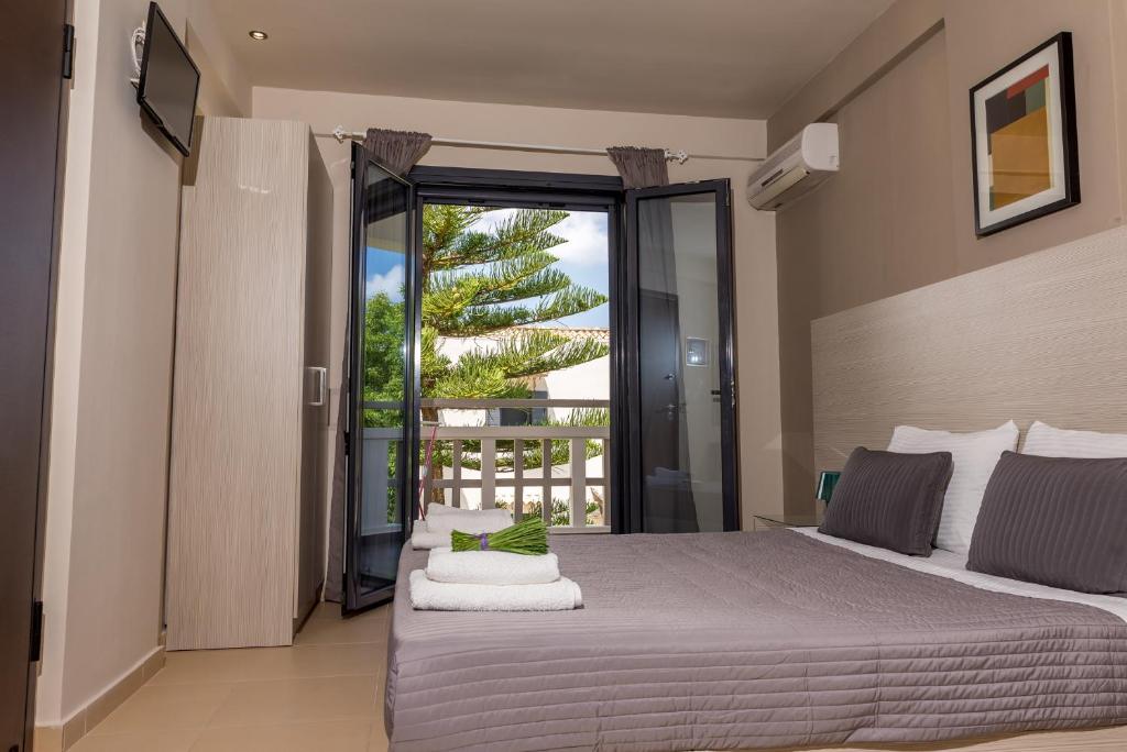 a bedroom with a large bed and a balcony at Trianon Studios in Tsilivi