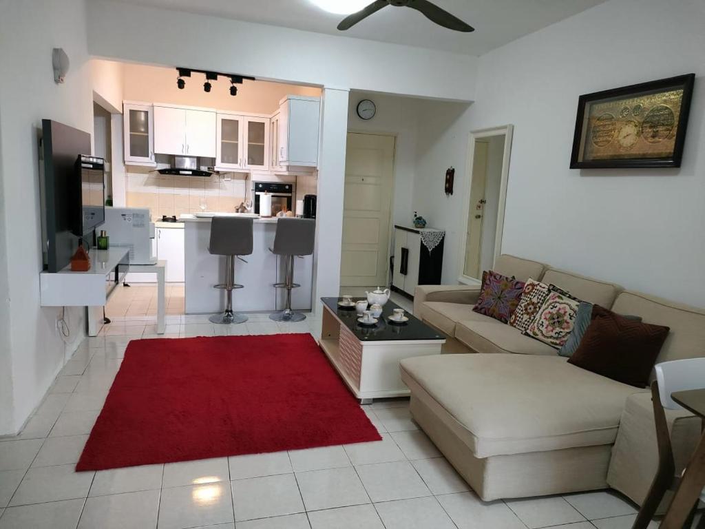 ein Wohnzimmer mit einem Sofa und einem roten Teppich in der Unterkunft Permai Puteri Homestay Ampang in Ampang