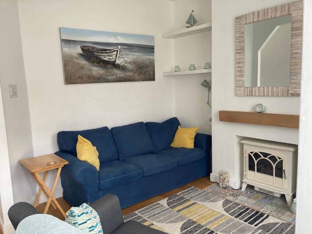 a living room with a blue couch and a fireplace at Beresford81 in Cowes