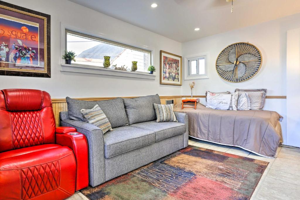 un soggiorno con divano e sedia rossa di Central Elmont Studio with Great Outdoor Space! a Elmont