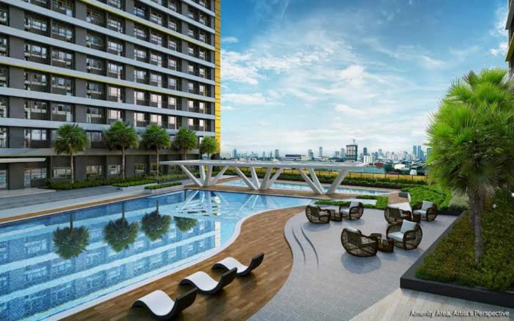 a hotel with a swimming pool and a building at Cozy 1BR with balcony at Fame Residences in Manila