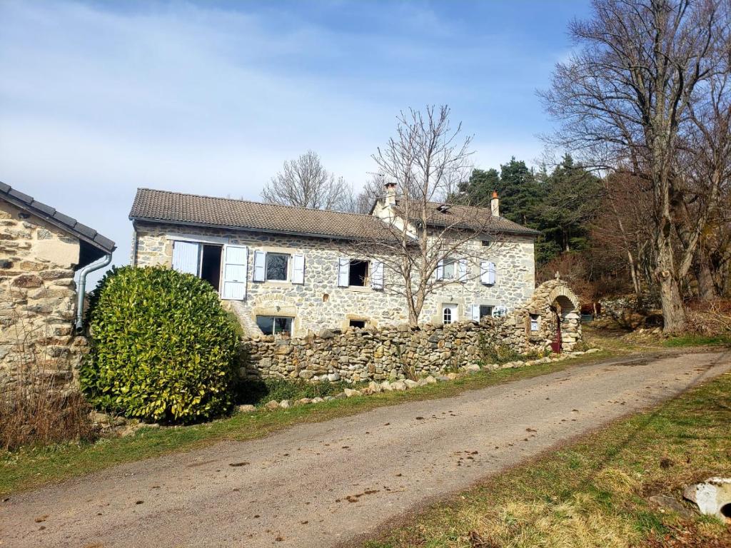 uma casa de pedra ao lado de uma estrada em La Chabanade em Saint-Pierre-Eynac