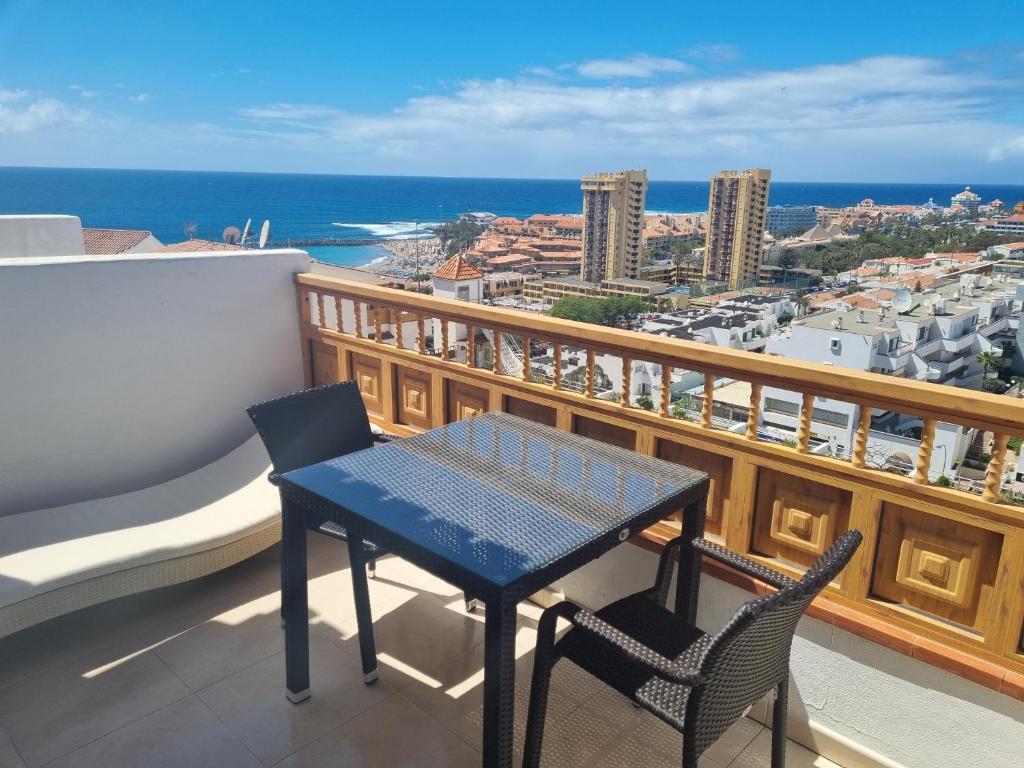 un tavolo blu e sedie su un balcone con vista sull'oceano di Ocean View Apartment Los Cristianos a Los Cristianos