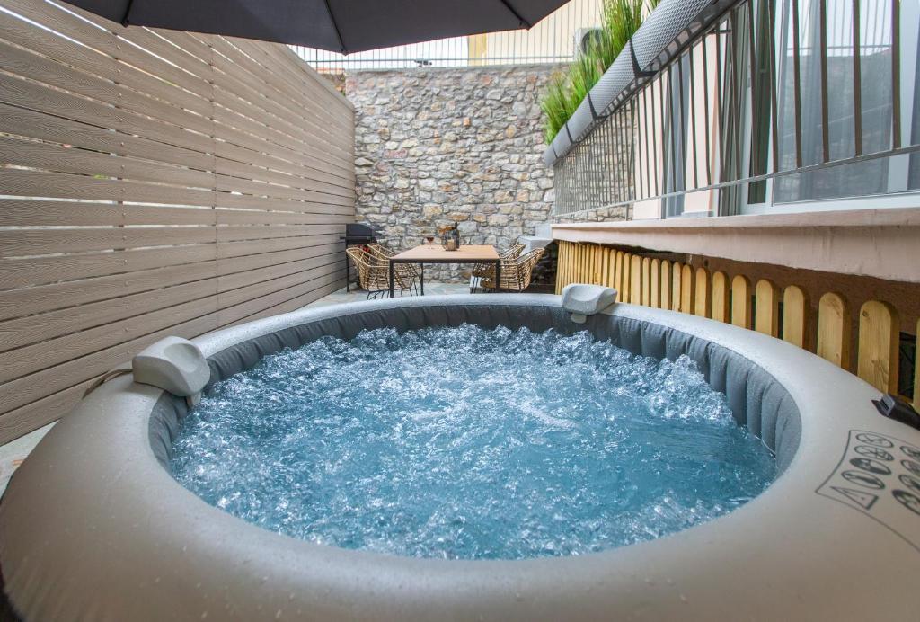 a hot tub in the middle of a patio at Lepanto Luxury Apartments GF in Nafpaktos