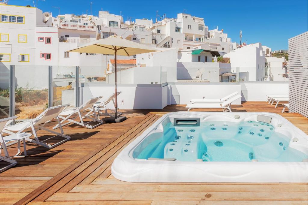 a hot tub on the roof of a house at Hotel Baltum in Albufeira