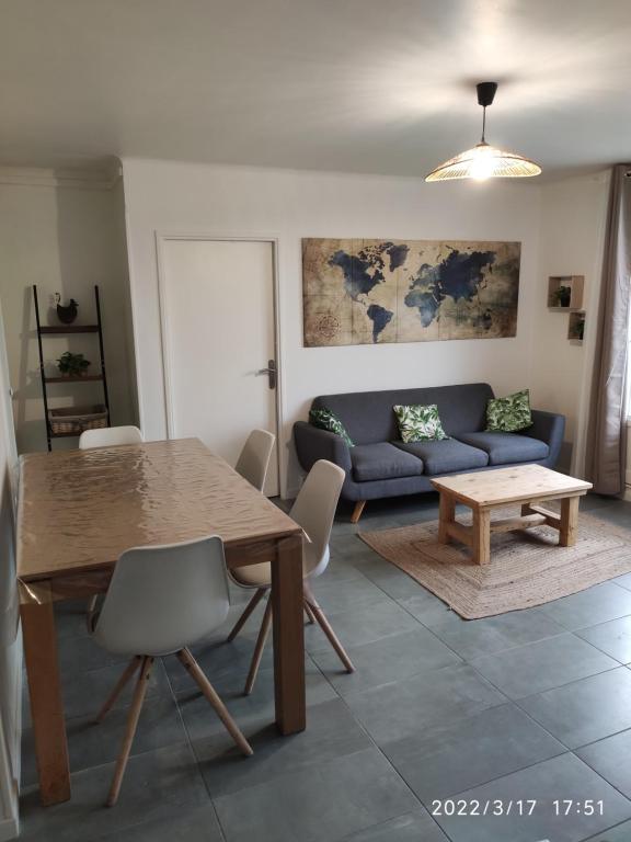 a living room with a table and a couch at Les Tamaris in Arles