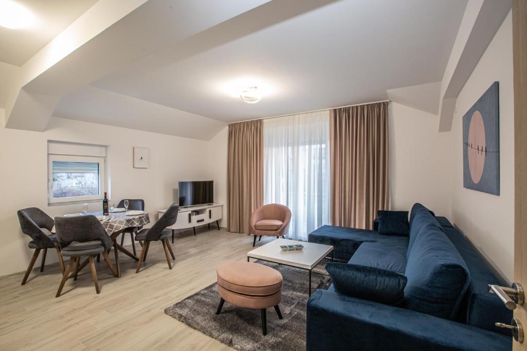 ein Wohnzimmer mit einem blauen Sofa und einem Tisch in der Unterkunft Rest Apartments in Nikšić