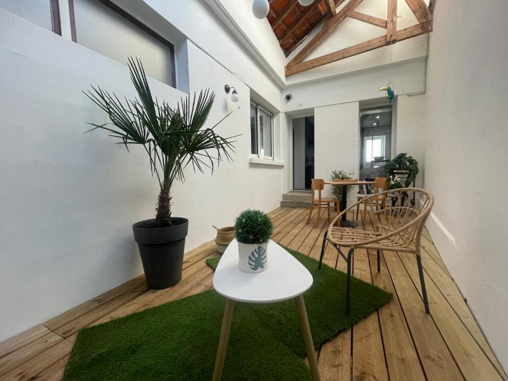 een kamer met een tafel en stoelen en een potplant bij Le Patio Combes de Mons in Royan