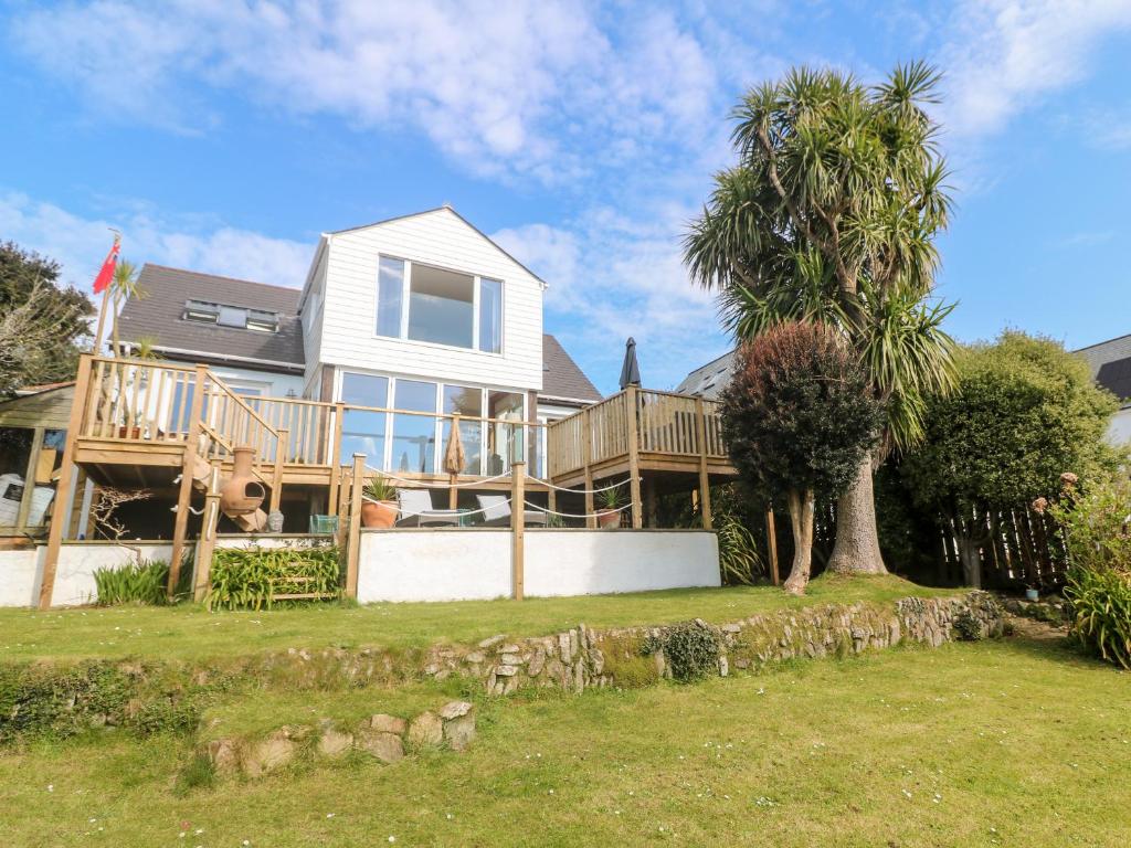 a house with a deck and a palm tree at Trewartha in Penzance