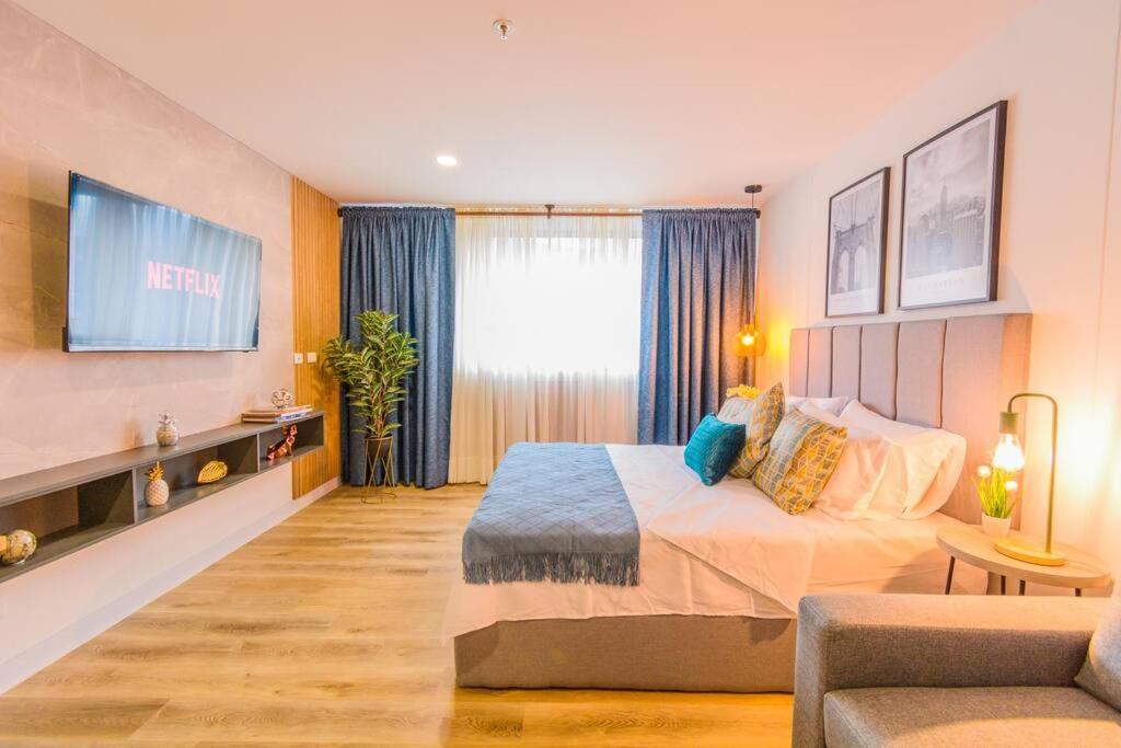 a hotel room with a bed and a couch at Luxury Suite in El Poblado Co-Work, Gym, Fast WiFi in Medellín