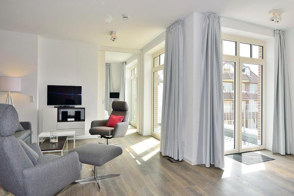 a living room with two chairs a table and a tv at Aparthotel Anna Düne Aparthotel Anna Düne 2-39 in Wangerooge
