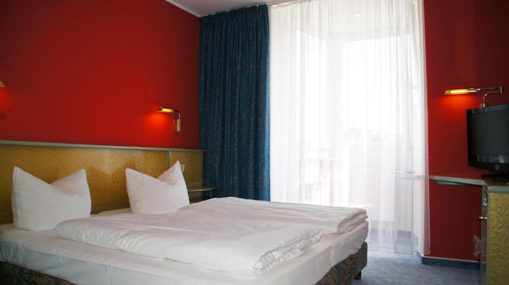 Postel nebo postele na pokoji v ubytování Hotel am Buschkrugpark