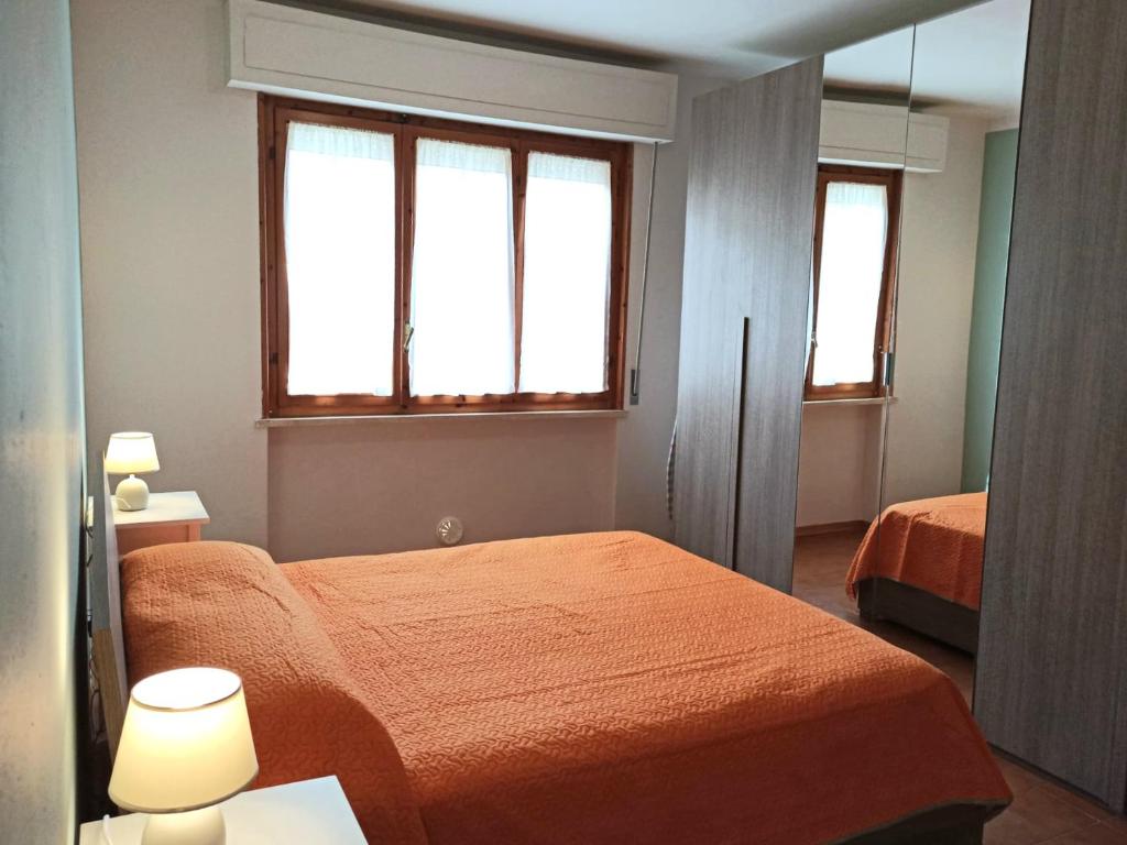 Casa Prati في مارينا دي سيسينا: غرفة نوم بسريرين ونوافذ