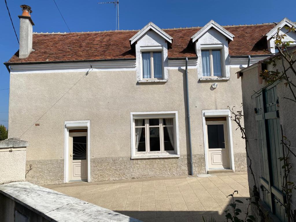 a house with white windows and a roof at Le gîte de Charline in Selles-sur-Cher
