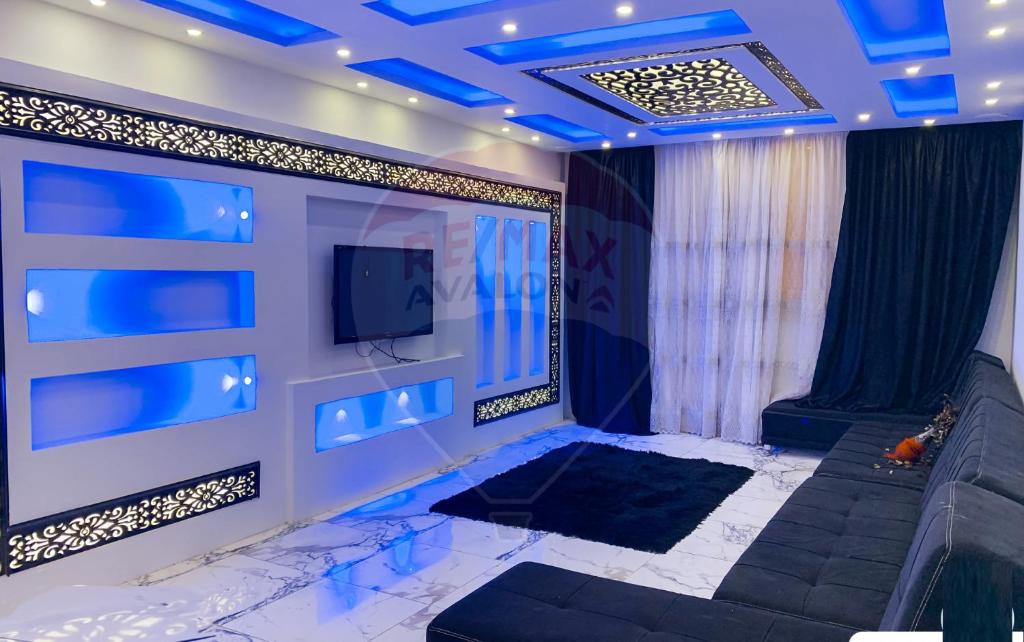 un soggiorno con TV e luci blu di شقة فخمة فيوالبحر Luxury Panorama Sea View ad Alessandria d'Egitto