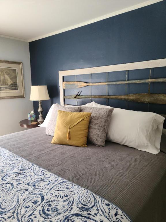 1 dormitorio con 1 cama grande y pared azul en Benjamin F. Packard House Bed and Breakfast en Bath