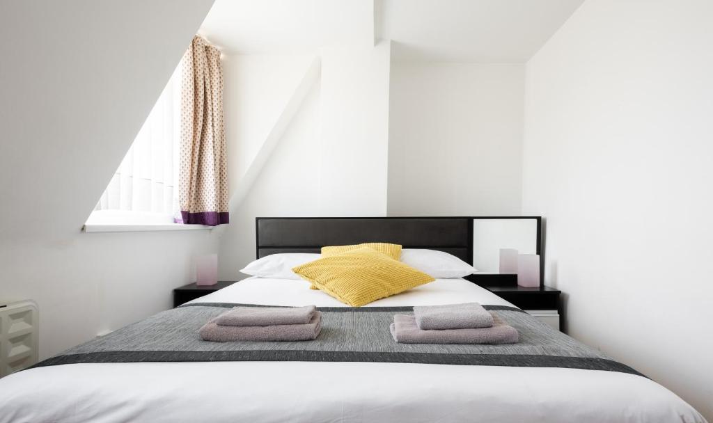 a bed with a white comforter and pillows at Central Hoxton Shoreditch in London