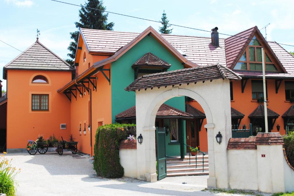 an orange and green house with an archway at l'Auberge des Gourmets Hôtel Restaurant in Le Vaudioux