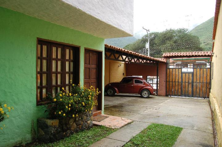 un'auto parcheggiata in un garage accanto a una casa verde di Cabañas Falconia a Mérida